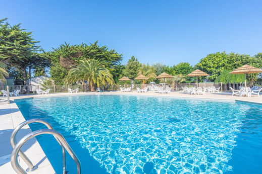 Piscina exterior, sillas y sombrillas en camping CLICOCHIC Camp du Soleil, Ars-en-Ré.