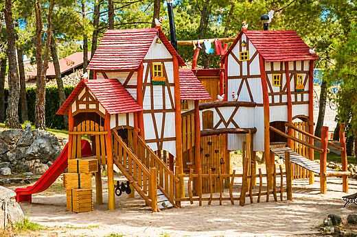 Gran parque infantil de madera con tobogán y puentes en el camping CAPFUN El Canto La Gallina en Valdemaqueda (Madrid).