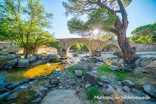 Puente de piedra y río en Valdemaqueda, lugar para visitar cerca del camping.
