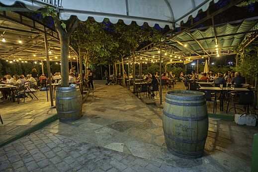 Restaurante exterior iluminado con comensales en CAPFUN El Canto La Gallina.