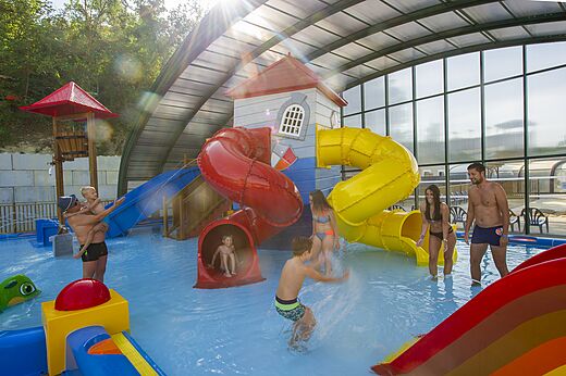 Toboganes y juegos acuáticos en la piscina cubierta del camping CAPFUN Carpe Diem.