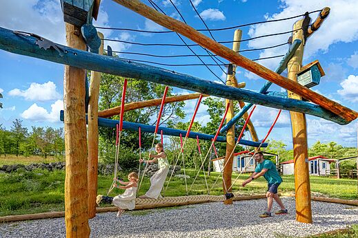 Estructura de juegos de madera y columpio de cuerda en el camping CLICOCHIC Castillon de Provence.