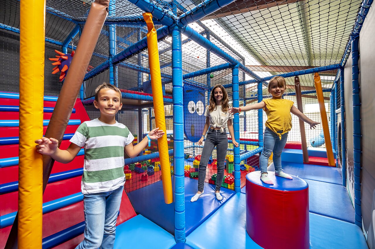 �rea de juegos interior con ni�os y estructuras coloridas en el camping CAPFUN Cenic.