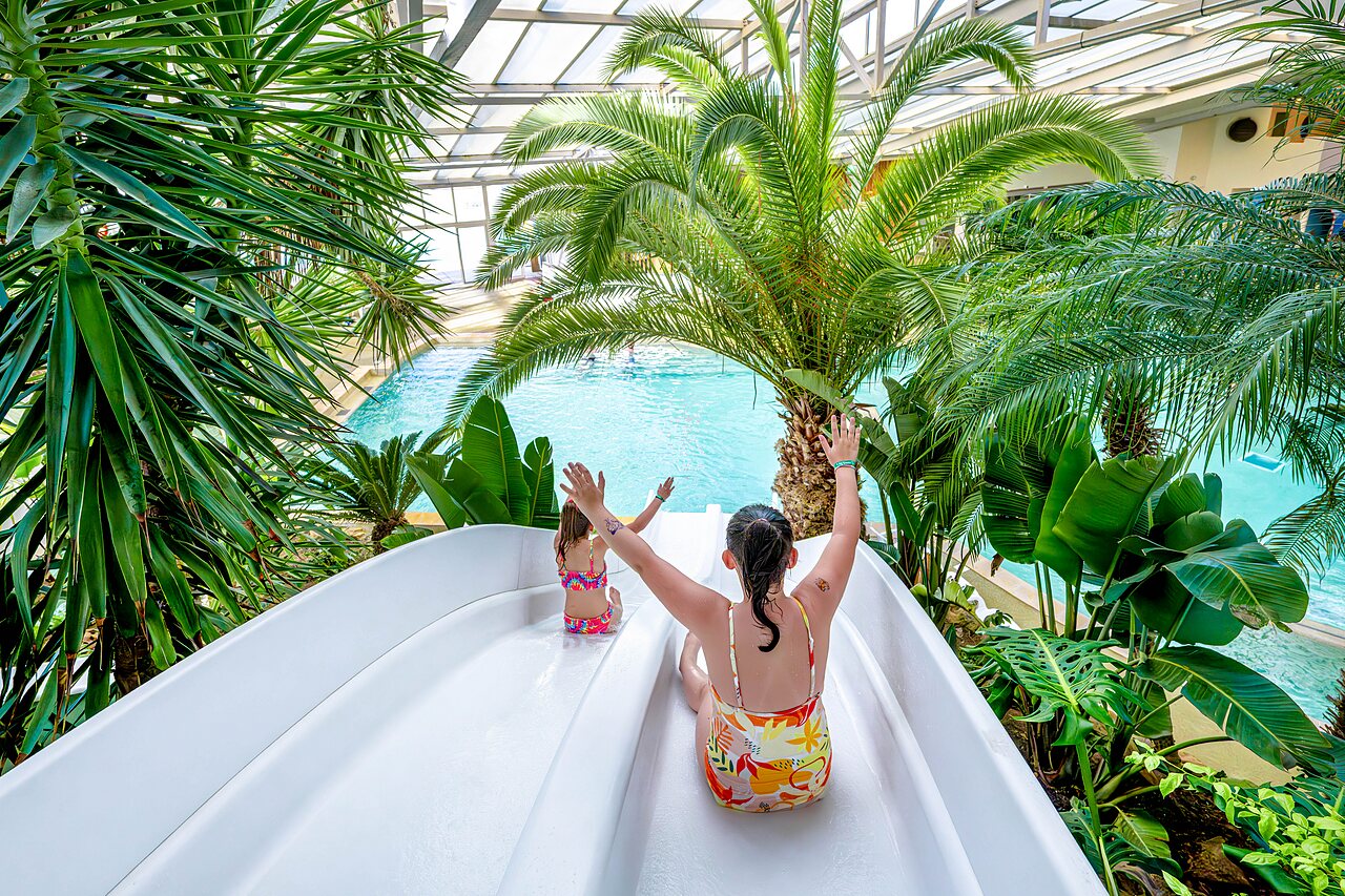 Tobog�n acu�tico y piscina cubierta con ni�os en el camping CAPFUN Cenic en PENESTIN (56).