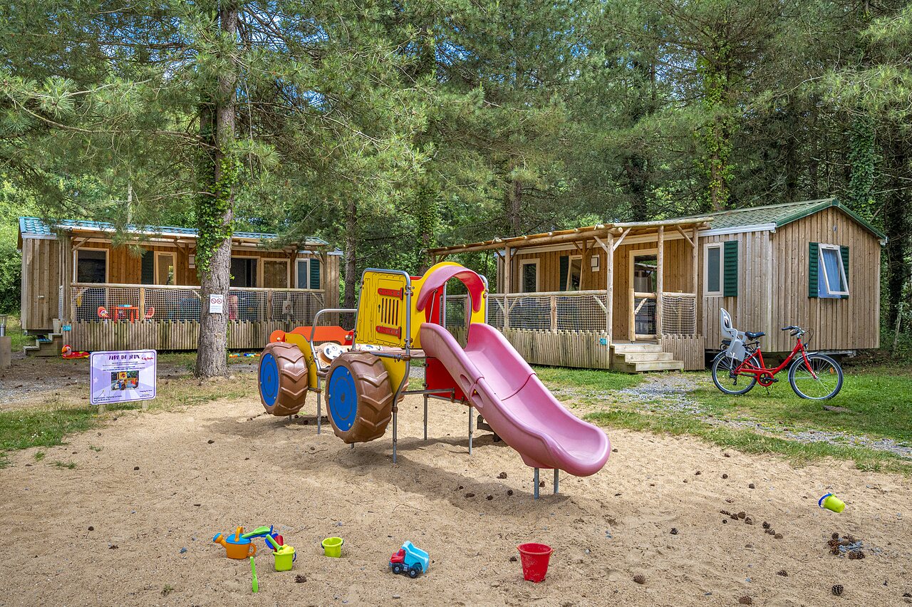 Zona de juegos con tobog�n y Mobil-homes en el camping CAPFUN Cenic en PENESTIN (56).