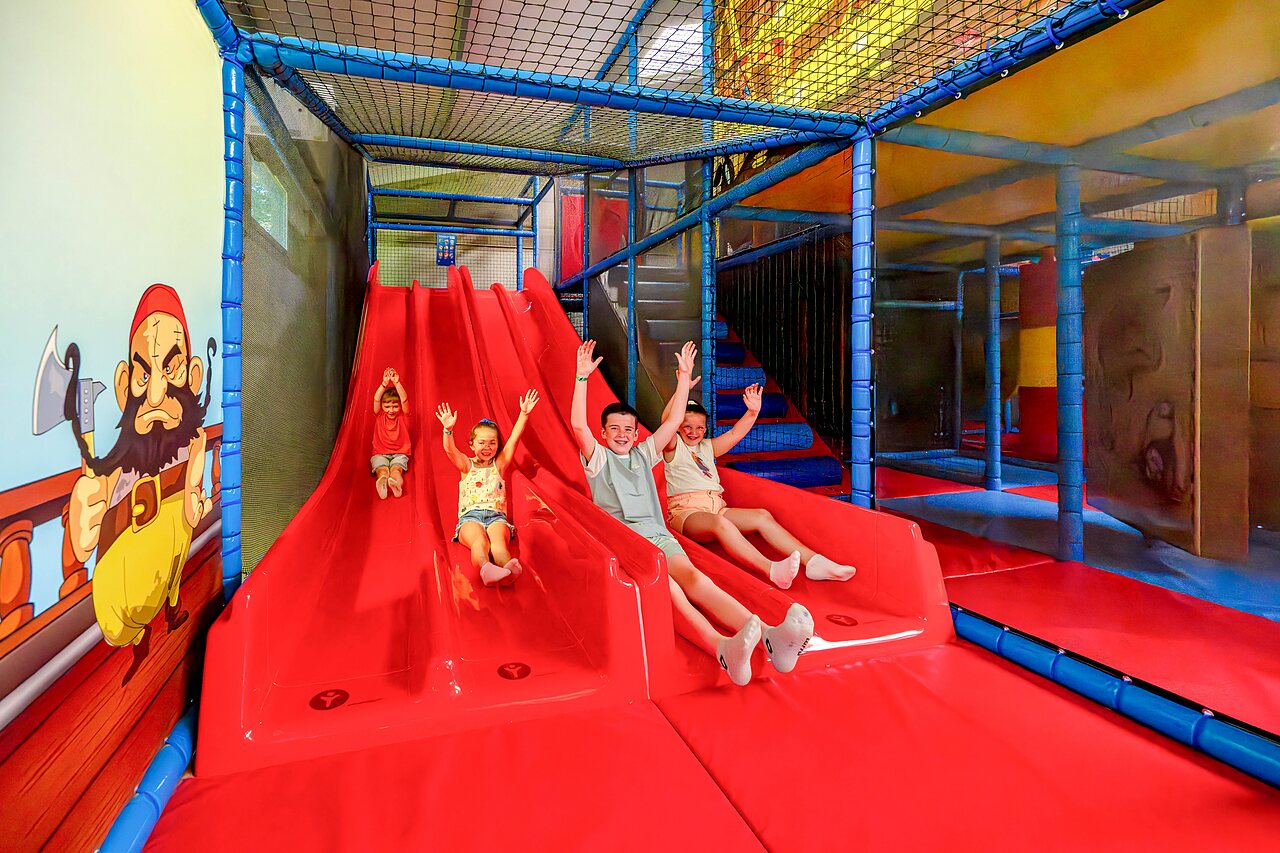 Zona de juegos interior con toboganes y ni�os en camping CAPFUN Cenic PENESTIN (56).