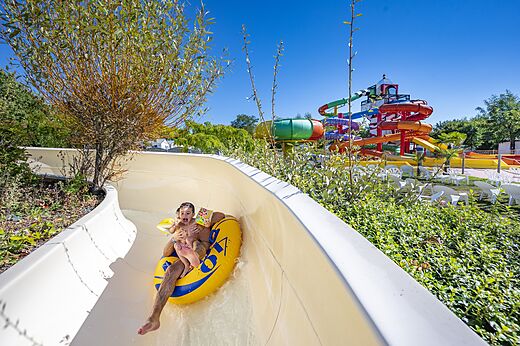 Ni�o y adulto en flotador tobog�n acu�tico en camping CAPFUN Cenic en PENESTIN (56).