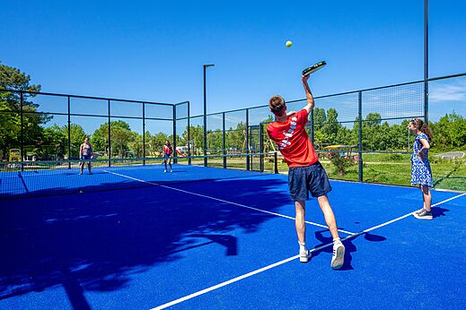 Pista de pádel azul y jugadores en el camping CAPFUN Cenic en PENESTIN (56).