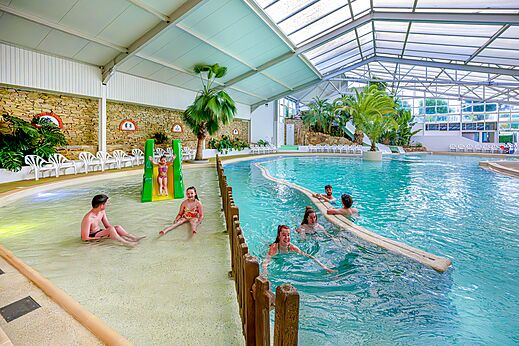 Piscina cubierta con tobogán y zona infantil en el camping CAPFUN Cenic en PENESTIN (56).