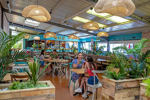 Zona de bar y restaurante moderna con clientes en camping CAPFUN Cenic en PENESTIN (56).