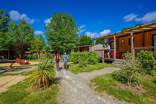 Casas m�viles con terrazas y personas en bicicleta en el camping CAPFUN Cenic en PENESTIN (56).