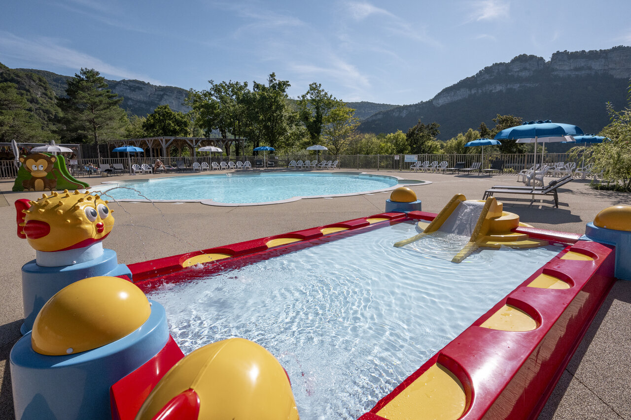 Piscina exterior, piscina infantil con tobog�n y juegos acu�ticos en el camping CLICOCHIC Chancia en Chancia (01).