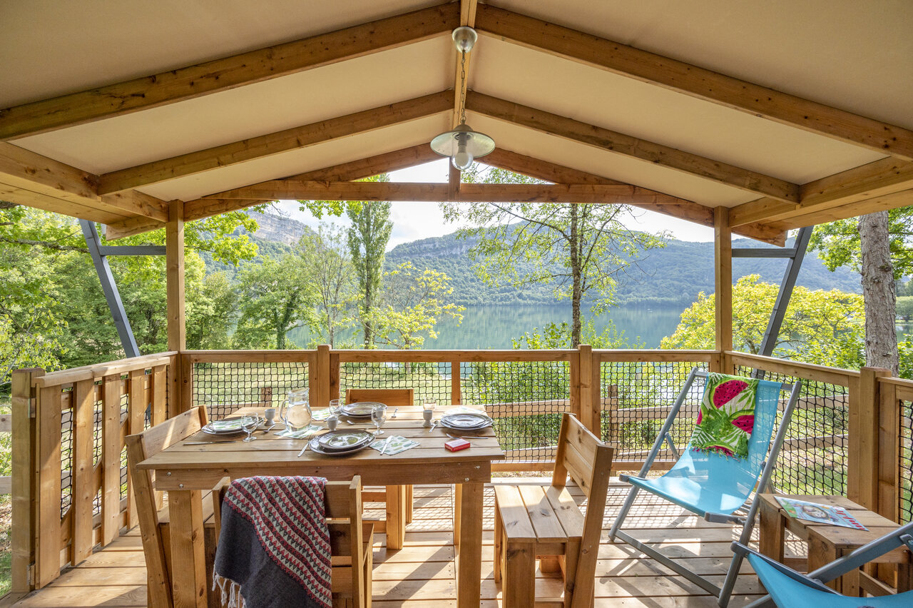 Terraza cubierta de alojamiento con mesa y vista lago en CLICOCHIC Chancia (01).