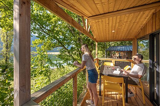 Terraza de alojamiento con vistas al lago y la naturaleza en el camping CLICOCHIC Chancia en Chancia (01).