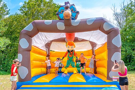Castillo hinchable gigante con niños y mascota en el camping CLICOCHIC Chancia en Chancia (01).