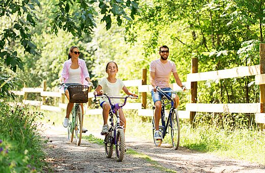 Familia en bicicleta por sendero arbolado en el camping VAGUES OCEANES Domaine les Charmilles en Saint-Laurent-de-la-Prée (17).