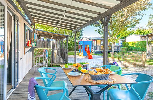 Terraza de Mobil-home con desayuno y zona de juegos en el camping VAGUES OCEANES Domaine les Charmilles en Saint-Laurent-de-la-Prée (17).