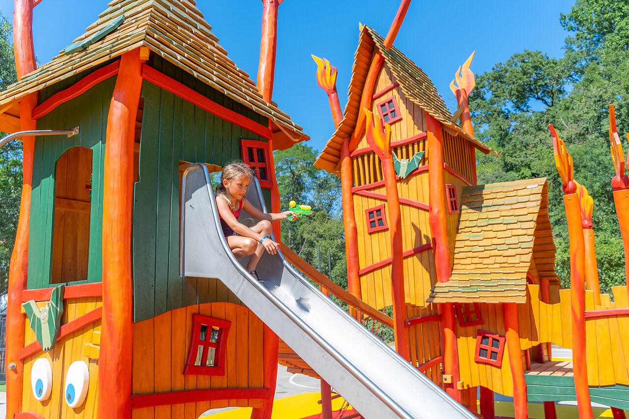 Zona de juegos colorida con tobog�n y ni�a en el camping CLICOCHIC Ch�teau de Boisson en All�gre-les-Fumades (30).