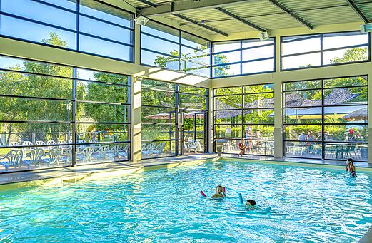 Piscina cubierta luminosa con niños en el camping CAPFUN Château de Galinée (22).