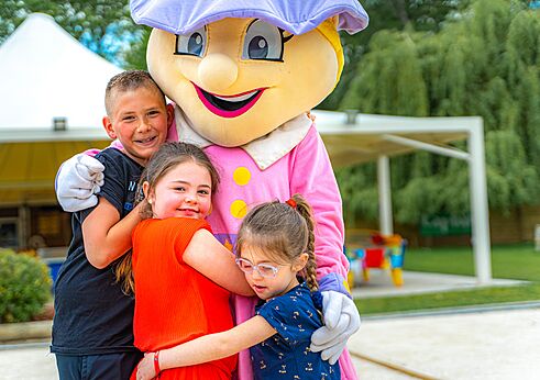 Mascota del camping abrazando ni�os sonrientes en CAPFUN La Ch�naie PORNIC (44).