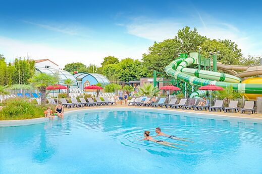 Piscina exterior, toboganes gigantes y sillas en camping CAPFUN La Chênaie PORNIC (44).