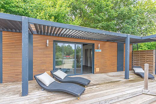 Mobil-home moderno con terraza de madera y sillas en el camping CAPFUN La Ch�naie en PORNIC (44).