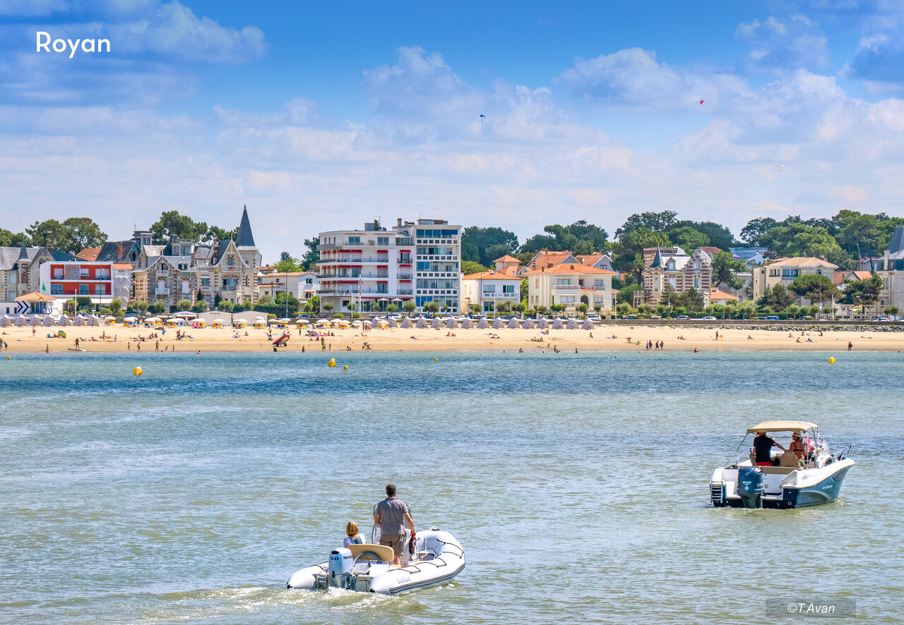 Playa de Royan con ba�istas, barcos y arquitectura costera en Charente-Maritime.