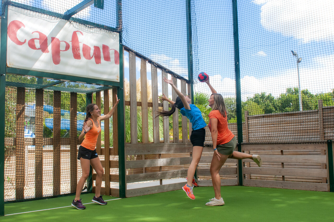 Mujeres jugando a la pelota en cancha multideporte en el camping CAPFUN Ch�nes en Medis/Royan.