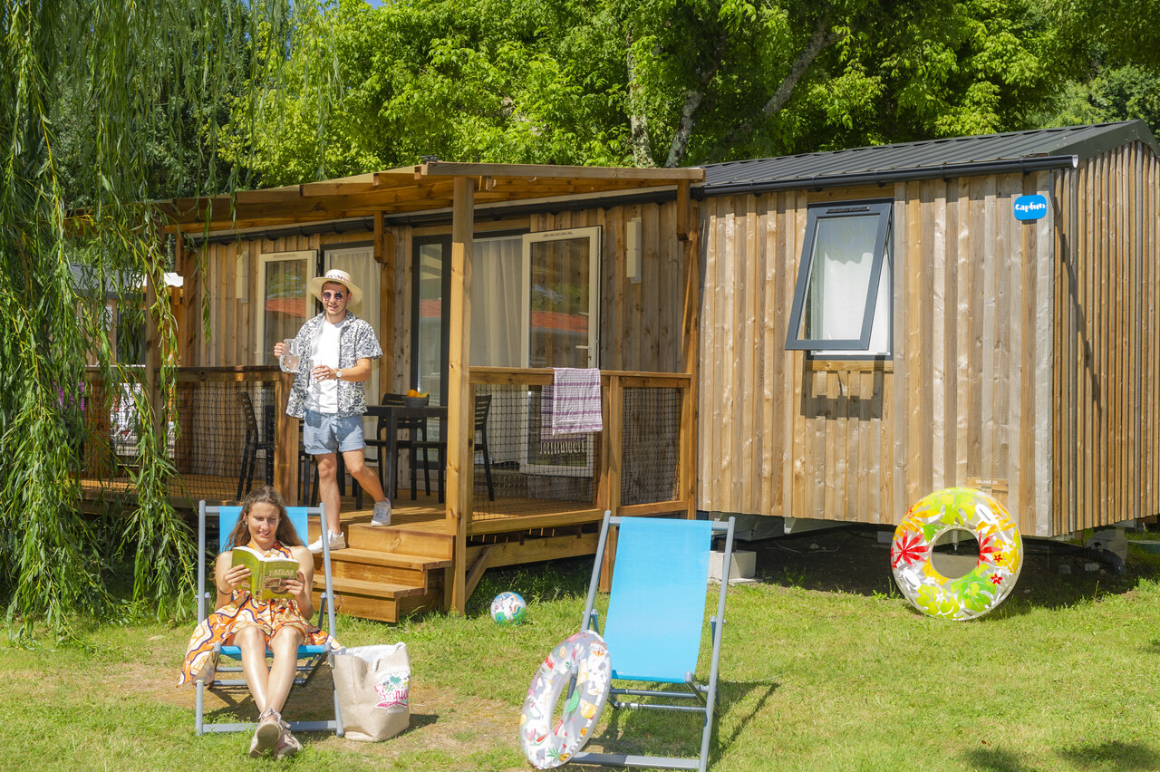 Mobil-home moderno con terraza, pareja relaj�ndose en el camping CAPFUN Ch�nes en Medis/Royan (17).