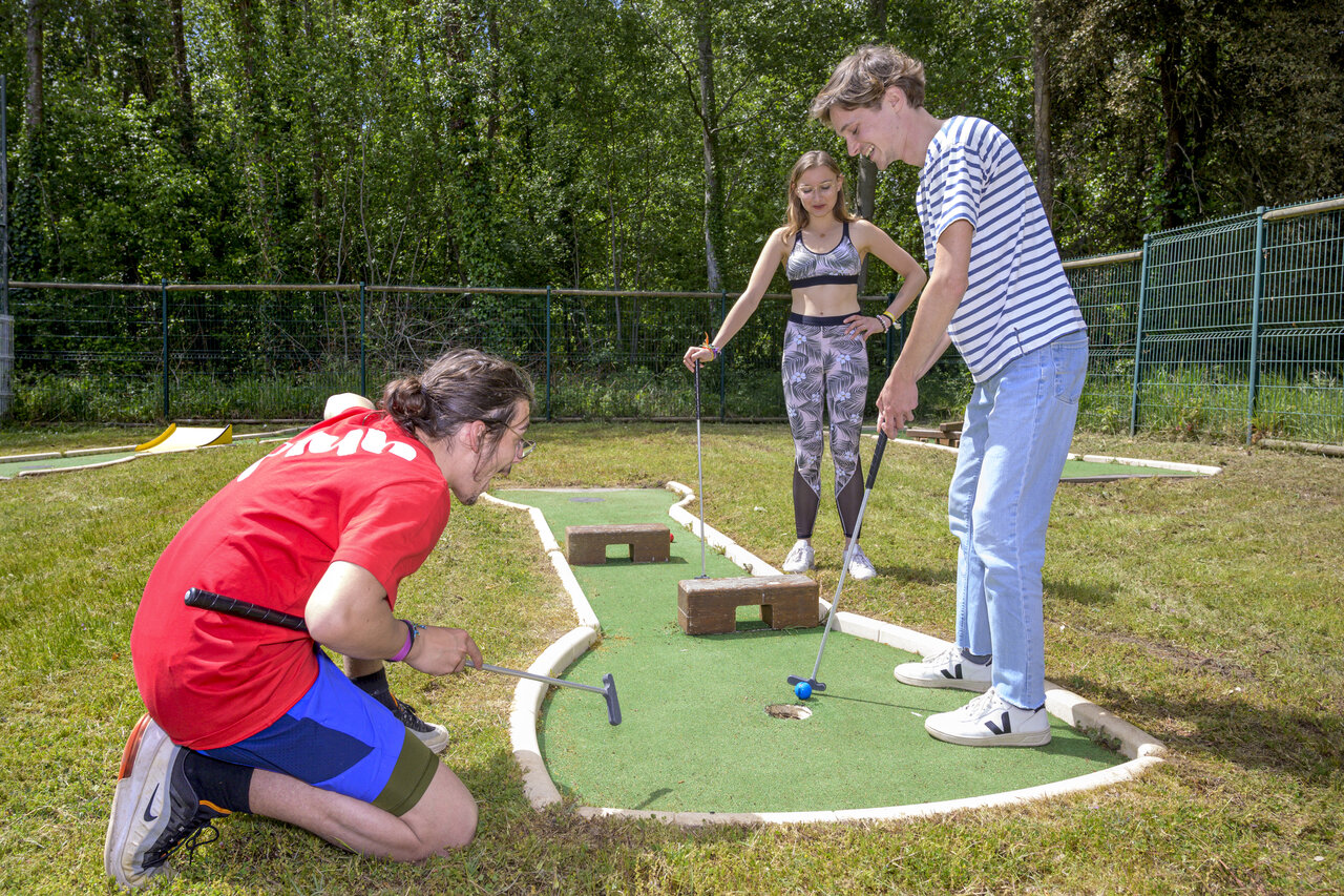 J�venes divirti�ndose en el minigolf del camping CAPFUN Ch�nes en Medis/Royan.