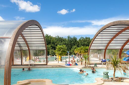 Piscina cubierta y exterior con tobogán en el camping CAPFUN Chênes en Medis/Royan (17).