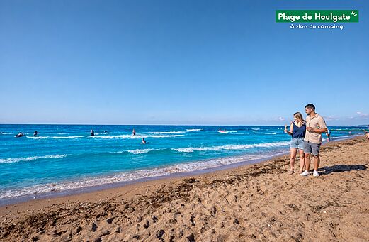 Playa de Houlgate con bañistas y pareja, lugar para visitar cerca del camping.