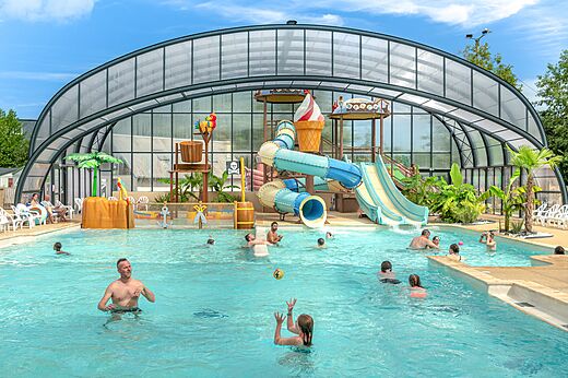Piscina cubierta con toboganes y juegos acuáticos en camping CLICOCHIC Chevaliers Houlgate.