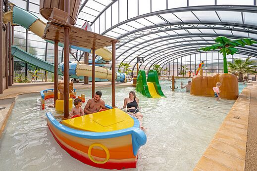 Zona acuática cubierta con piscina, toboganes y juegos de agua en el camping CLICOCHIC Chevaliers en HOULGATE (14).