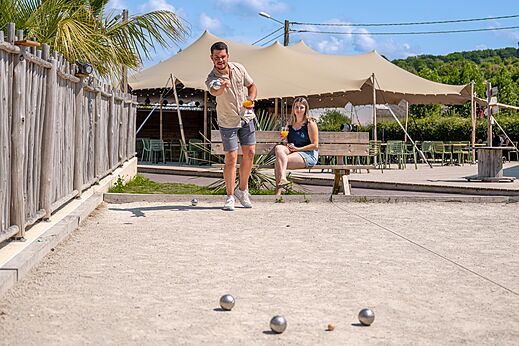 Campo de petanca con jugadores en el camping CLICOCHIC Chevaliers en HOULGATE (14).