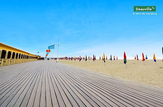 Paseo de Deauville, playa y sombrillas coloridas en Normandía, Francia.