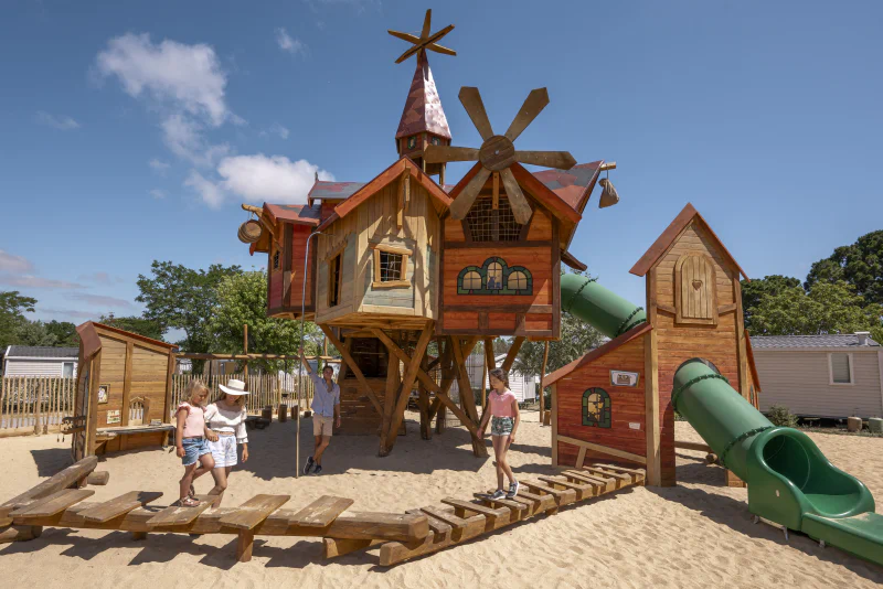 �rea de juegos de madera con toboganes en camping CLICOCHIC Chouans (85).