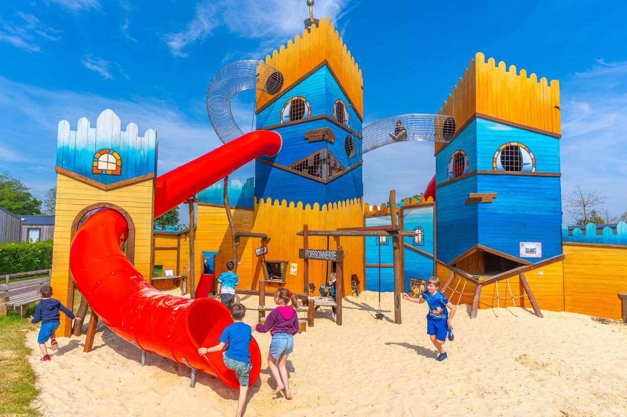 Zona de juegos castillo, tobog�n, ni�os en el camping CAPFUN Citadelle de Loustic.