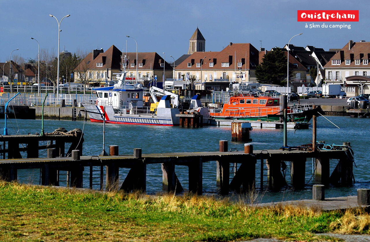 Puerto de Ouistreham con barcos de rescate y edificios hist�ricos en Normand�a.