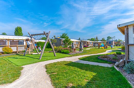 Columpio de madera y parque infantil cerca de los Mobil-homes en el camping CAPFUN Citadelle de Loustic en Hermanville sur Mer (14).