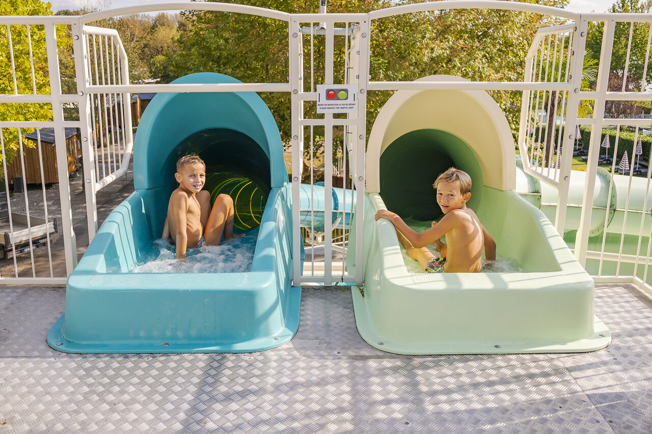 Toboganes acu�ticos con ni�os sonrientes en el camping CAPFUN Citta di Angera VA.