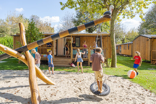 Zona de juegos con columpio y ni�os frente a Mobil-homes en el camping CAPFUN Citta di Angera en Angera VA (21).