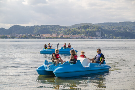 Familias en patinetes acu�ticos en el lago, camping CAPFUN Citta di Angera.