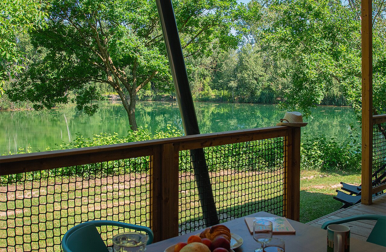 Terraza de alojamiento con vista al lago en el camping CLICOCHIC Au Clair Ruisseau en Gerstheim.
