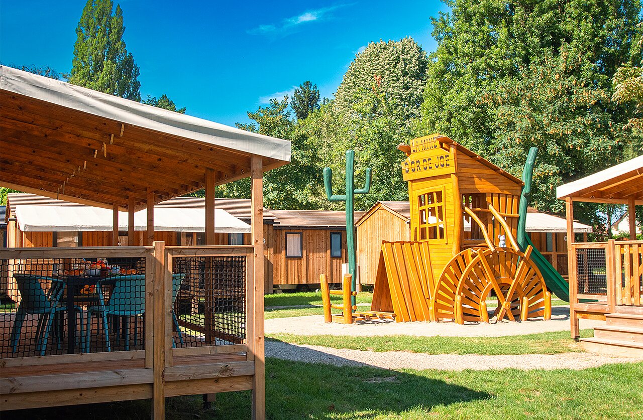 �rea de juegos western y terraza de alojamiento en el camping CLICOCHIC en Gerstheim (67).