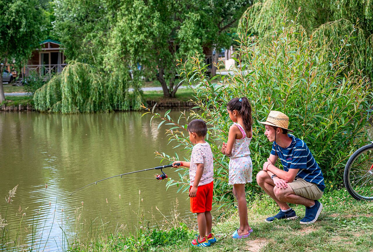 Ni�os pescando en el estanque natural del camping CLICOCHIC Au Clair Ruisseau en Gerstheim (67).