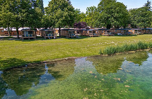 Mobil-homes de madera con terrazas junto al agua en el camping CLICOCHIC.