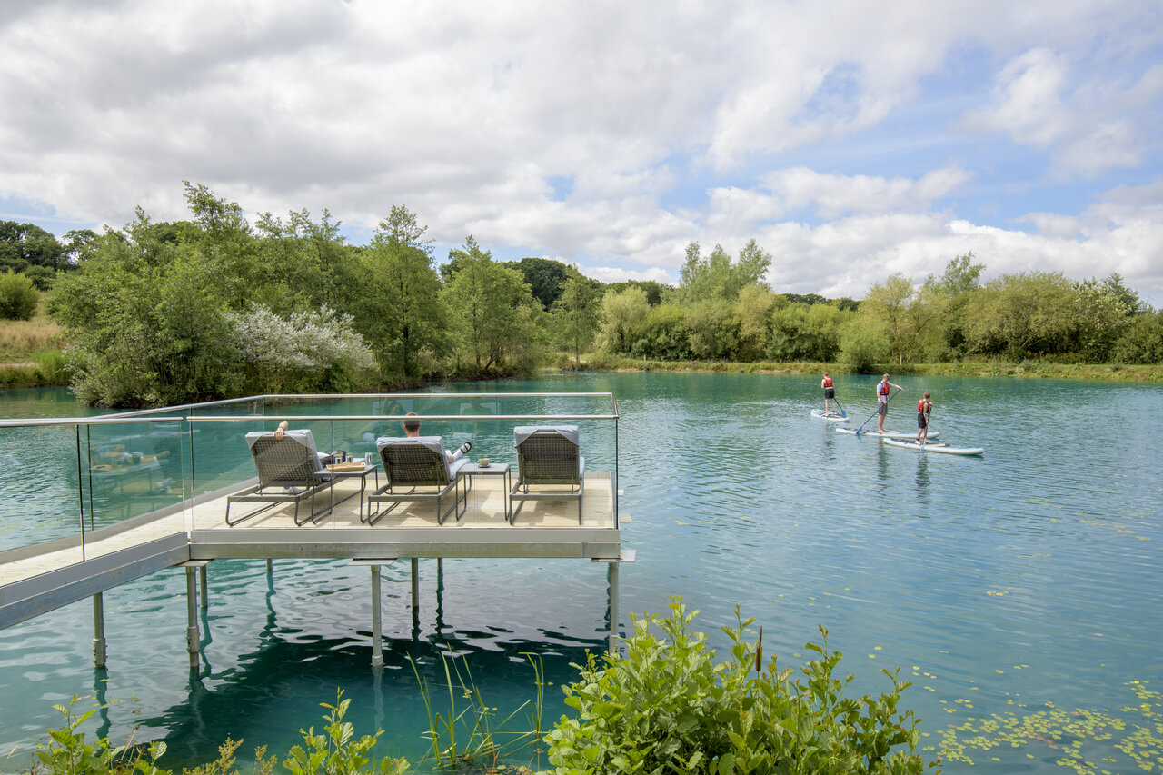 Paddleboarders en el lago y terraza de relajaci�n en el camping CAPFUN UK Clawford Lakes en Clawton, Holsworthy.