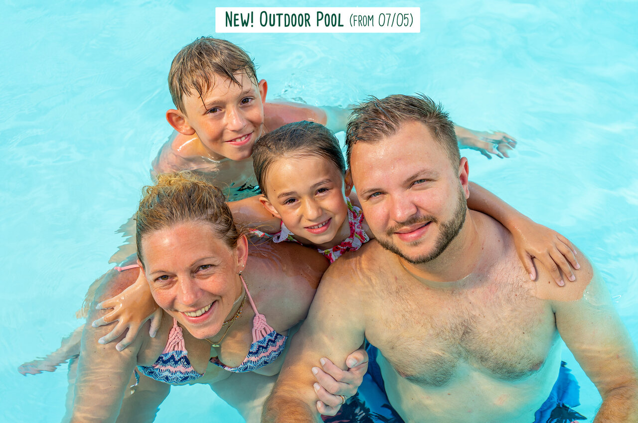 Familia sonriente disfrutando de la nueva piscina exterior en el camping CAPFUN UK Clawford Lakes en Clawton, Holsworthy.