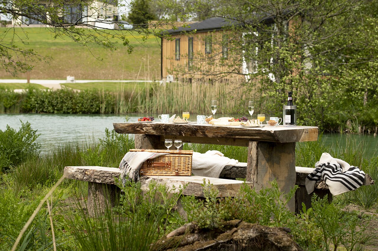 Mesa de picnic junto al lago en el camping CAPFUN UK Clawford Lakes en Clawton, Holsworthy.